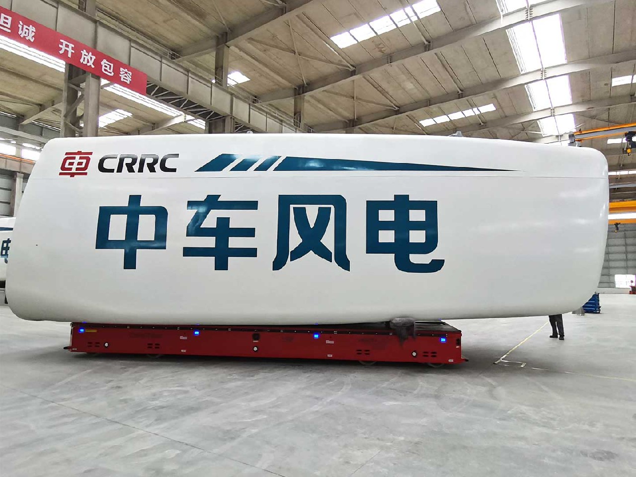 Four wheeled transport vehicles are used for the transportation of wind turbine nacelle components